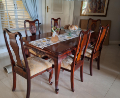 Vintage-style mahogany table with ball and claw legs and eight upholstered chairs. With French High-leg XV Antique sideboard and Chest of drawers